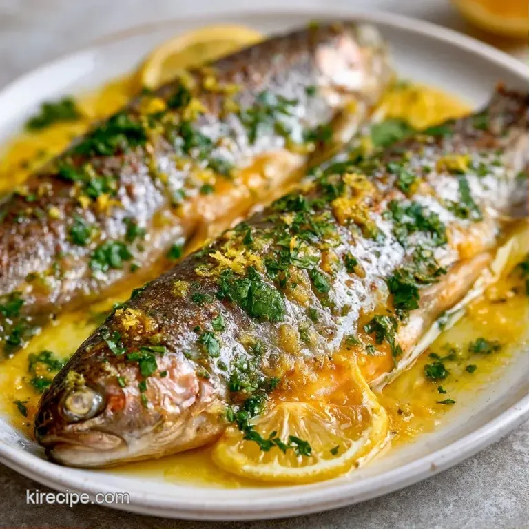 Flaky pink trout fillet served on a white ceramic plate with steamed asparagus and a bright, juicy lemon wedge