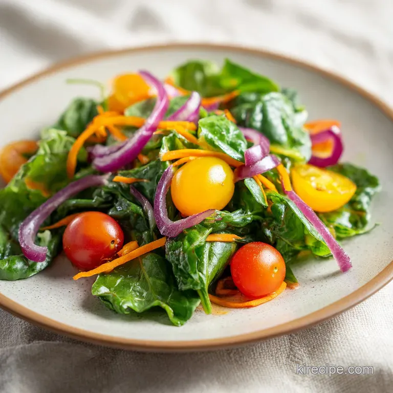 Brightly colored garden vegetables and leafy greens artfully arranged in a white bowl with a sheer lemon vinaigrette.