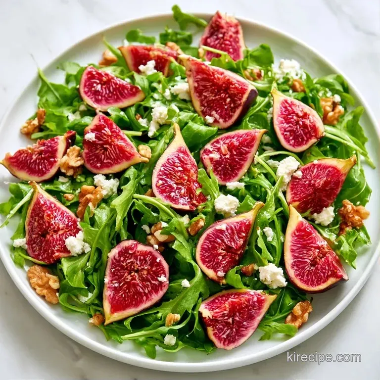 Slices of ripe purple figs and white cheese artfully arranged on a white ceramic plate with fresh green leaves.