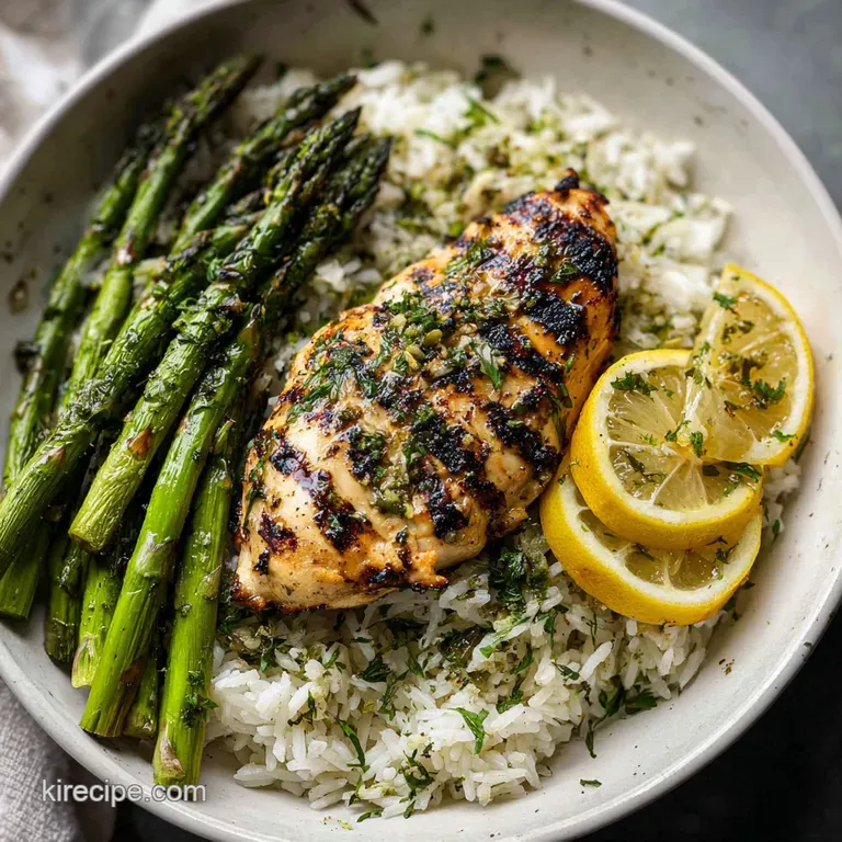 Perfectly grilled chicken atop a bed of rice; bright green asparagus spears add a fresh contrast on a clean white plate.