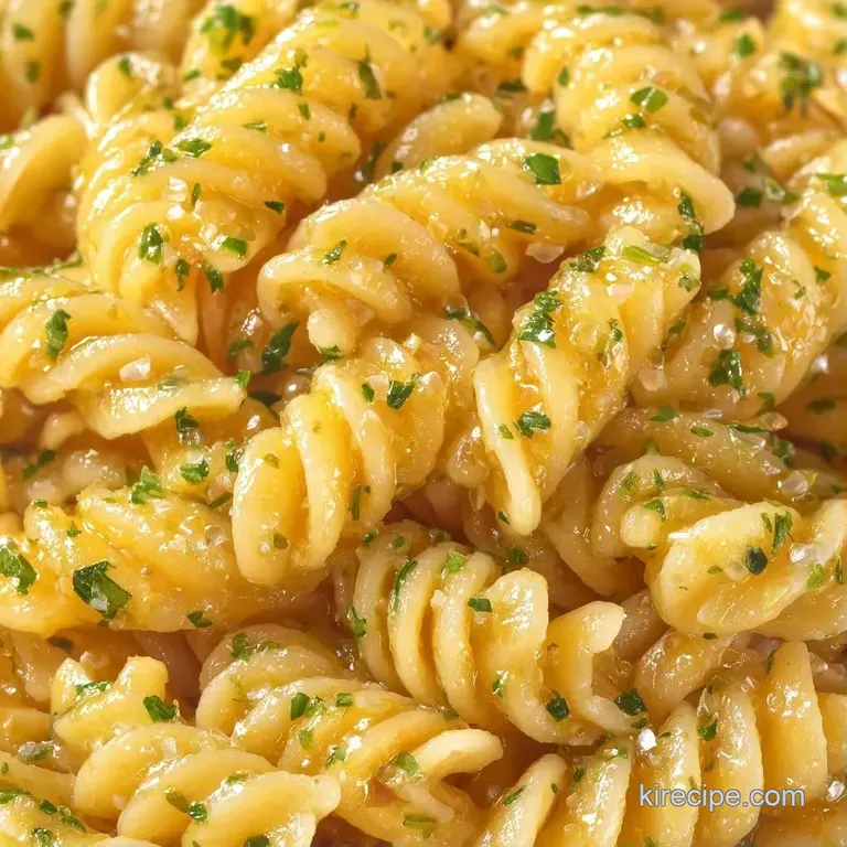 A vibrant mix of spiraled pasta, sliced olives, and fresh herbs tossed in a glistening herb-infused vinaigrette