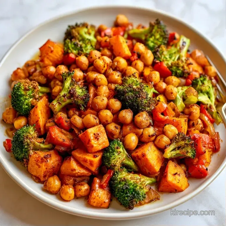 Elegant white plate featuring roasted golden chickpeas, charred red peppers, and a drizzle of creamy tahini sauce.